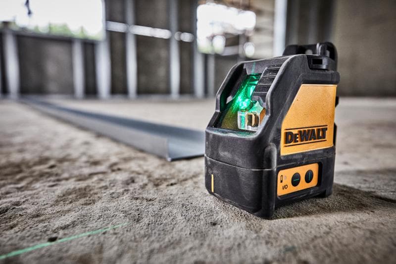 Nível a laser verde DEWALT DW088CG em piso de concreto de obra.
