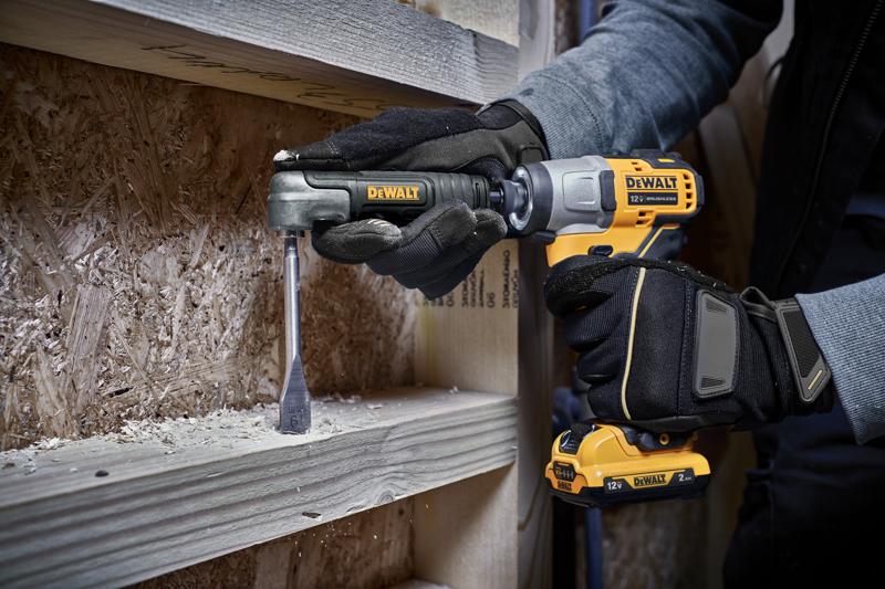 Uma pessoa com luvas utiliza uma furadeira sem fio DEWALT de 12V com um acessório de ângulo reto para perfurar uma tábua de madeira, com cavacos de madeira visíveis ao redor da área de trabalho.